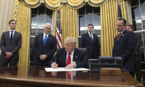 Donald Trump firma con marcadores negros